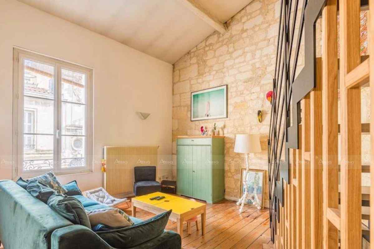 Phòng khách đơn giản với sofa nhung xanh và bàn gỗ màu vàng